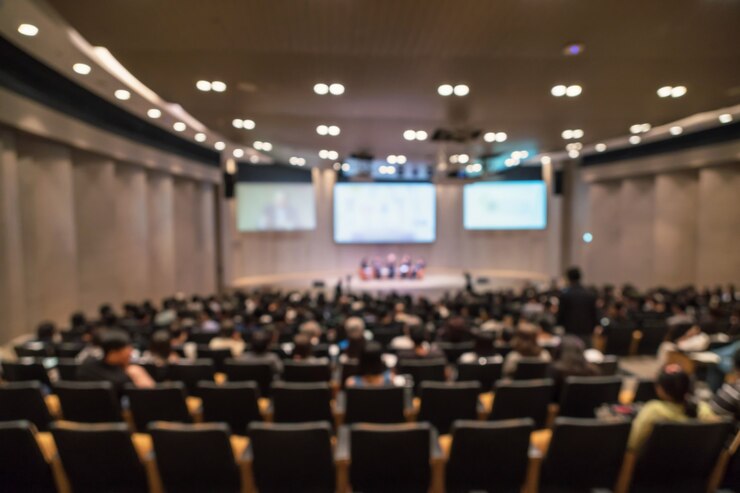 Foto foto desfocada abstrata de sala de conferências ou sala de seminário com alto-falantes no palco