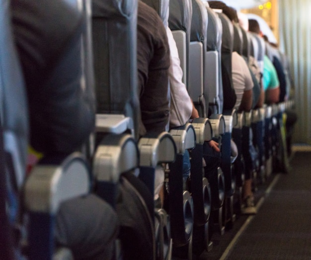 Foto desfocada do interior da aeronave. Passageiros na cabine do avião