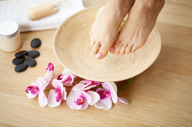 Foto de detalle de un pies femeninos en el salón de spa en el procedimiento de pedicura