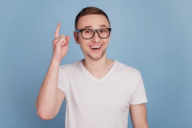 Foto de divertido inteligente joven emocionado dedo acusador con idea genio aislado fondo de color azul