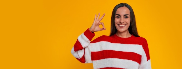 Foto do banner do retrato de uma linda mulher morena feliz enquanto ela mostra um grande sinal com um sorriso na câmera