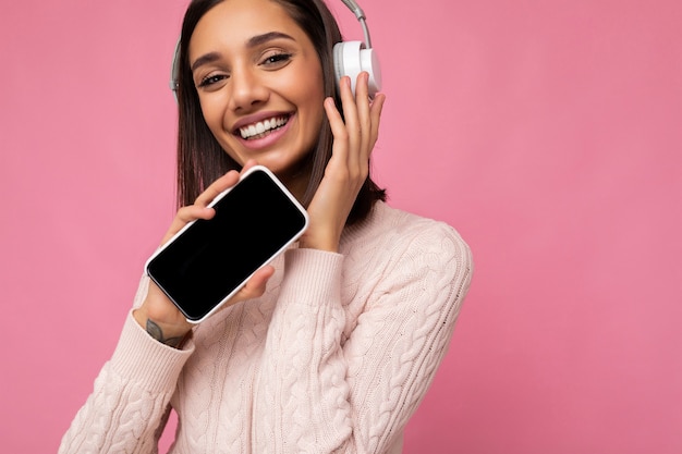 Foto do close up de uma bela jovem sorridente e feliz, vestindo uma roupa casual elegante isolada