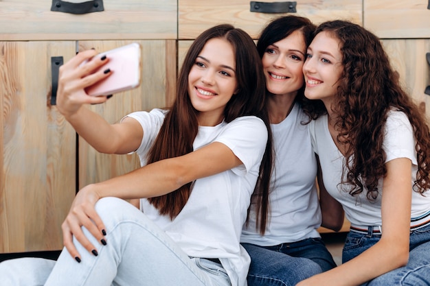 Foto do close up. Garotas bonitas e bonitas fazendo selfies em casa