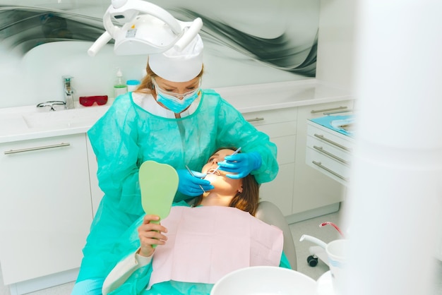 Foto do dentista e seu paciente no processo de examinar os dentes