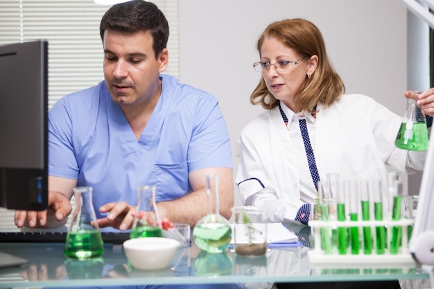 Foto do jovem assistente apresentando os dados que o principal cientista está dizendo a ele. laboratório de pesquisa. análise microbiológica.