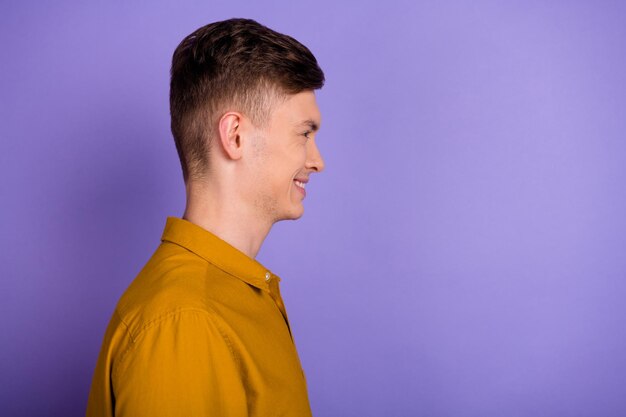 Foto do lado do perfil de um jovem alegre parece um profissional de espaço vazio isolado sobre fundo de cor violeta