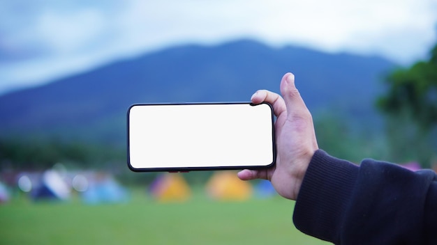 Foto do retrato de um homem segurando um celular no campo