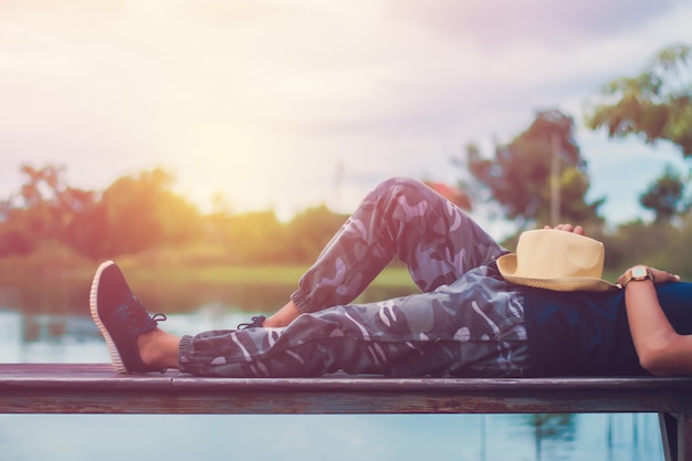 Foto do vintage do homem de relaxamento com apreciação do ar fresco no balcão de madeira pelo rio.