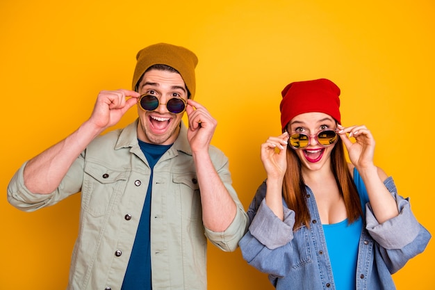 Foto de dos agradable alegre positivo aturdido gente despegando gafas aislado fondo amarillo verano