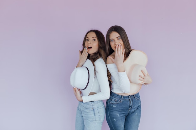 Foto de dos amigas emocionales que se encuentran aisladas sobre un fondo morado.