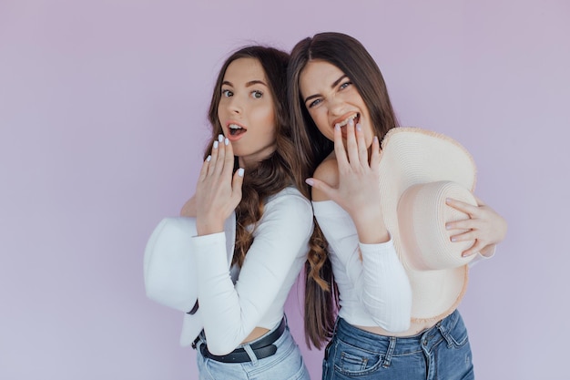 Foto de dos amigas emocionales que se encuentran aisladas sobre un fondo morado.