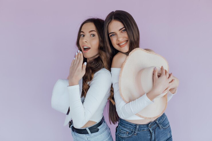 Foto de dos amigas emocionales que se encuentran aisladas sobre un fondo morado.