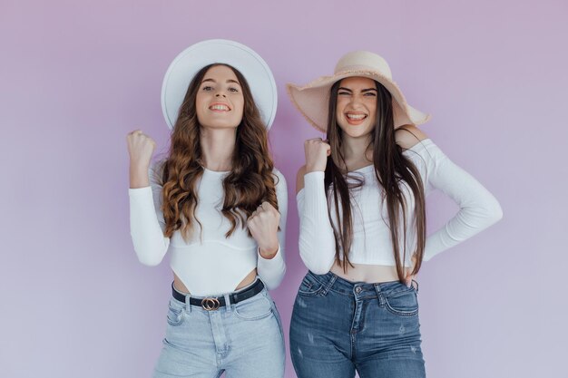 Foto de dos amigas emocionales que se encuentran aisladas sobre un fondo morado.