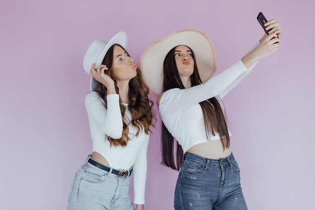 Foto de dos amigas emocionales que se encuentran aisladas sobre un fondo morado.