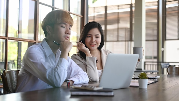 Foto de dos colegas de negocios discutiendo sobre la planificación de la estrategia de marketing en la oficina moderna