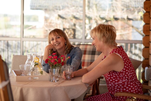 Foto de dos mujeres felices de 55 años que pasan tiempo juntos en casa