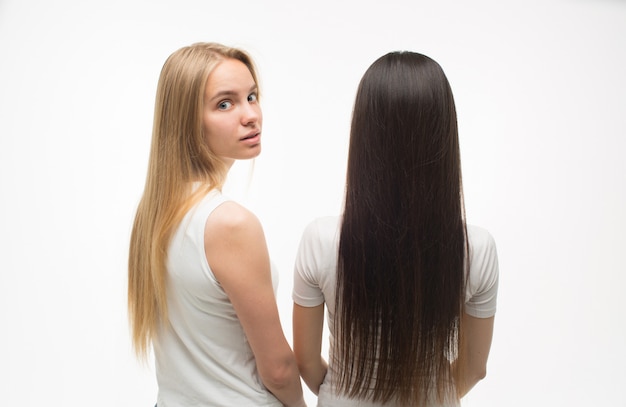 Foto de dos mujeres jóvenes paradas y una de ellas mirando hacia atrás