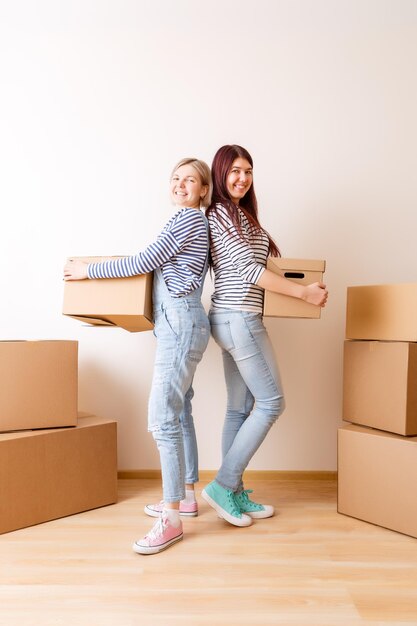 Foto de dos mujeres de pie entre cajas de cartón.