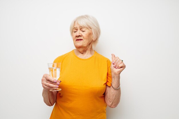 Foto einer alten Dame im Ruhestand in lässiger T-Shirt-Brille Glas Wasser beschnittene Ansicht