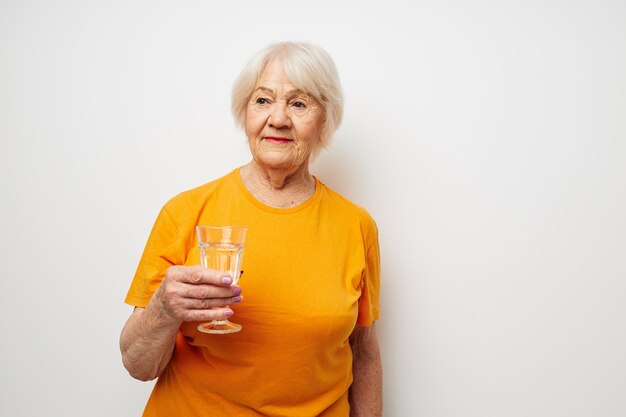 Foto einer alten Dame im Ruhestand in lässiger T-Shirt-Brille Glas Wasser beschnittene Ansicht