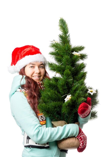 Foto foto einer frau mit weihnachtsmütze mit weihnachtsbaum in der hand