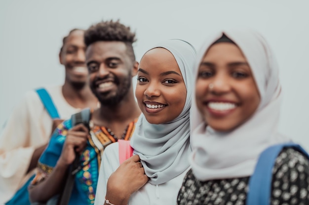 Foto einer Gruppe glücklicher afrikanischer Studenten, die miteinander reden und sich treffen, um an Hausaufgaben zu arbeiten, Mädchen, die den traditionellen sudanesischen muslimischen Hijab tragen. Hochwertiges Foto