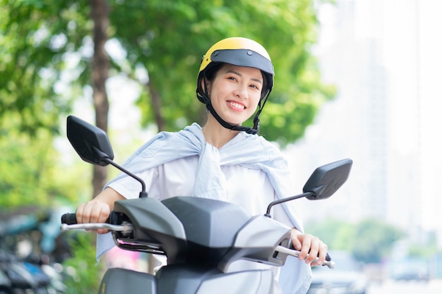 Foto einer jungen Asiatin, die Motorrad fährt