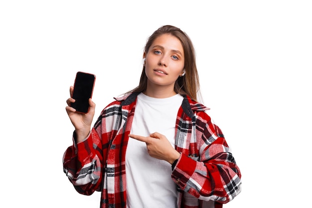 Foto einer jungen Frau im rotkarierten Hemd, die auf das Smartphone zeigt