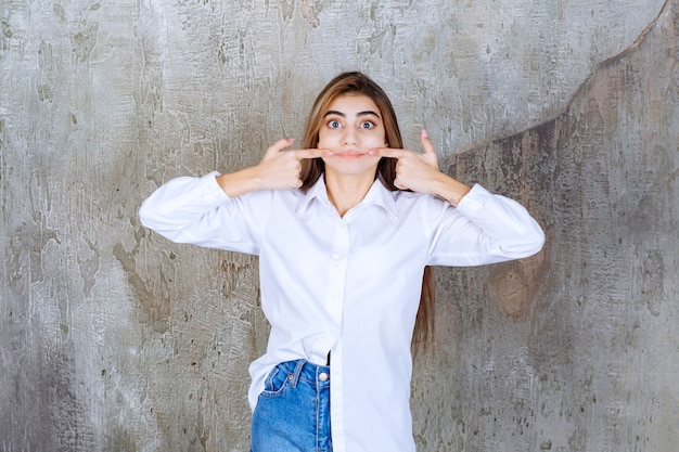 Foto einer jungen frau in weißer bluse, die über marmor steht