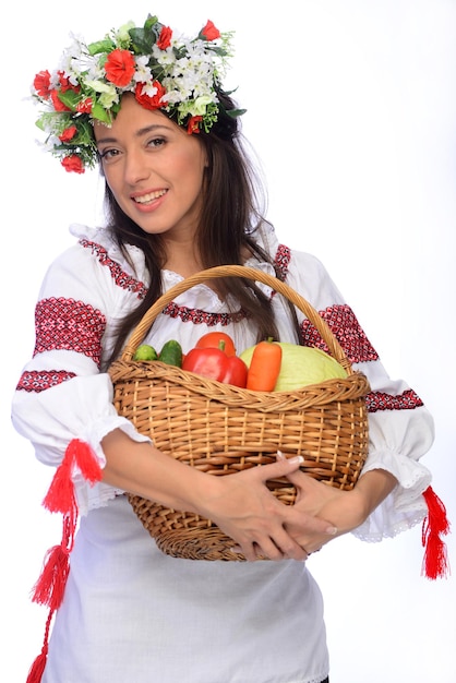 Foto einer schönen und süßen Frau in ukrainischer Tracht mit Gemüsekorb