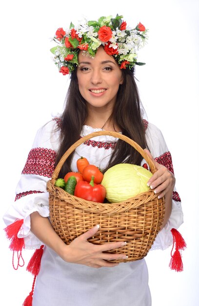 Foto einer schönen und süßen Frau in ukrainischer Tracht mit Gemüsekorb