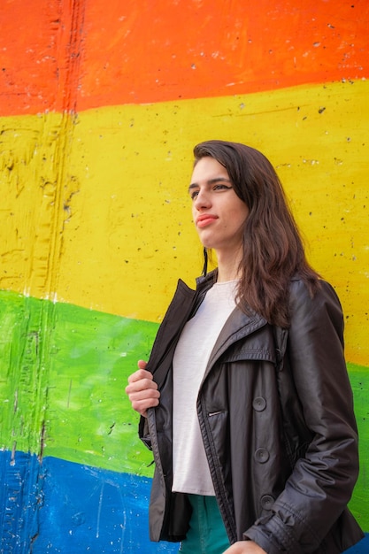 Foto einer transsexuellen Frau vor einer Wand mit der schwulen Regenbogenflagge Wir aktivieren LGTBIQ