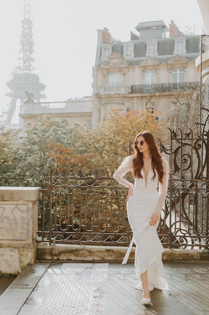 Foto einer wunderschönen brünetten Braut in einem luxuriösen Hochzeitskleid in Frankreich