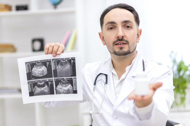 Foto eines Arztes im Laborkittel, der seinem Patienten ein Ultraschallergebnis zeigt