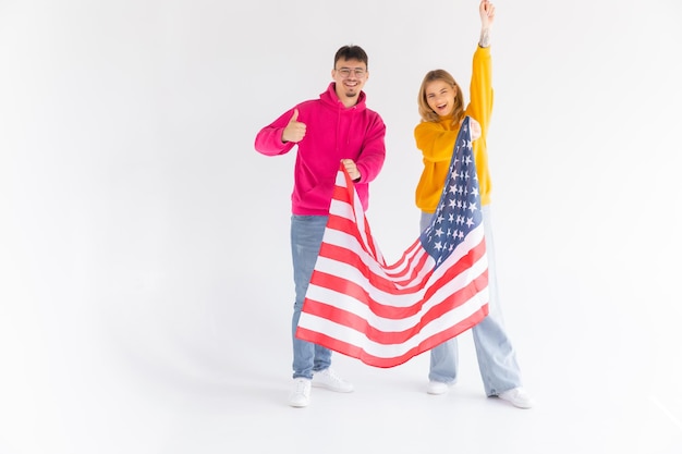 Foto eines attraktiven multiethnischen Paares, Mann und Frau, eingehüllt in amerikanische Flagge