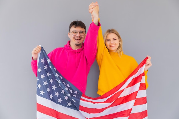 Foto eines attraktiven multiethnischen Paares, Mann und Frau, eingehüllt in amerikanische Flagge