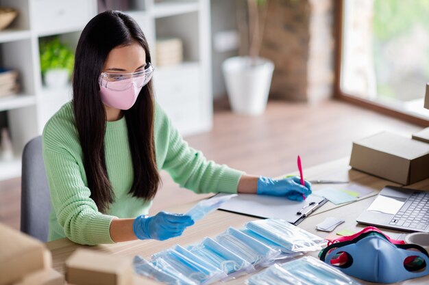 Foto eines chinesischen beschäftigten Damenfamilienunternehmens, das das Verpacken von medizinischen Gesichtsmasken für die globale Verbreitung organisiert