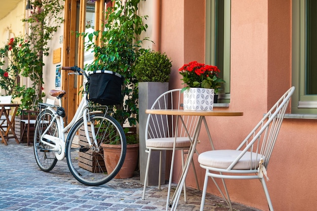 Foto eines Fahrrads, das in der Nähe eines Cafés auf der Straße steht