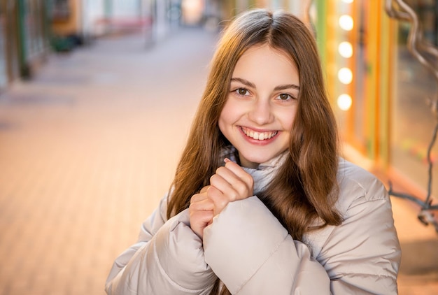 Foto eines fröhlichen Teenager-Mädchen-Porträts draußen Teenager-Mädchen-Porträt auf der Straße Teenager-Mädchen-Porträt im Freien Teenager-Mädchen-Porträt mit Hut