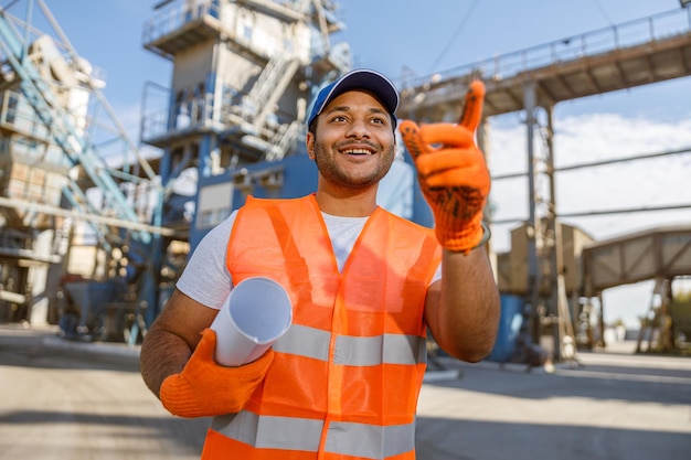 Foto eines glücklichen männlichen multiethnischen Arbeiters im Werk