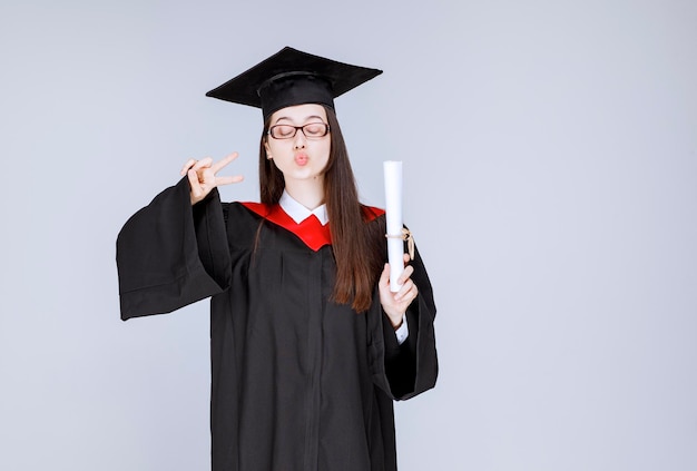 Foto eines intelligenten Studenten in Gläsern, der den Abschluss mit Diplom feiert. Foto in hoher Qualität
