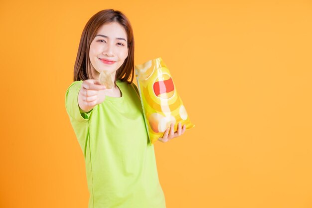 Foto eines jungen asiatischen Mädchens, das einen Snack im Hintergrund isst