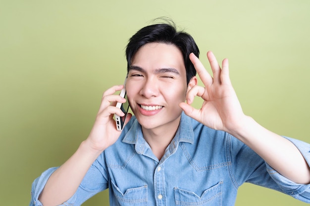 Foto eines jungen asiatischen Mannes auf grünem Hintergrund