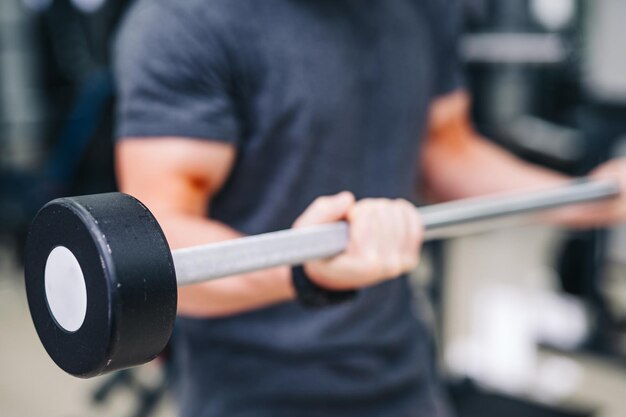 Foto eines starken Mannes, der Gewicht hält Aktives Leben mit Sport im Fitnessstudio