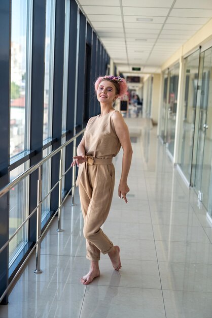 Foto em tamanho real de mulher romântica posando no corredor usando vestido rosa