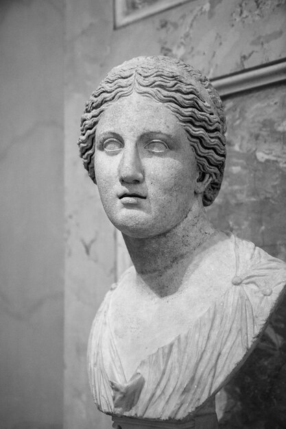 Foto em tons de cinza de uma estátua de mármore de uma mulher
