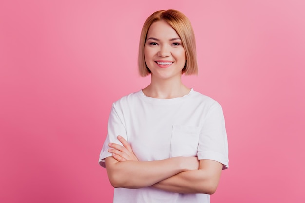 Foto de encantadora dama encantadora positiva brazos cruzados usar camiseta blanca aislada sobre fondo de color rosa