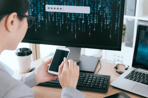 foto de enfoque selectivo de una trabajadora de oficina que toca la pantalla del teléfono móvil buscando una empresa de servicios de gestión de seguridad de contraseñas de cuentas.