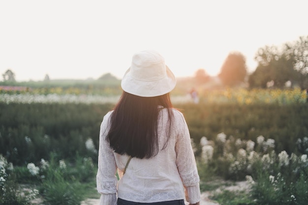 Foto de época de una joven relajante en un jardín de flores.