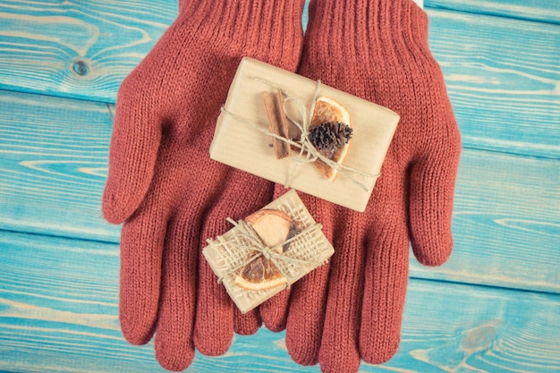 Foto de época Manos de mujer en guantes con regalos decorados para Navidad u otra celebración